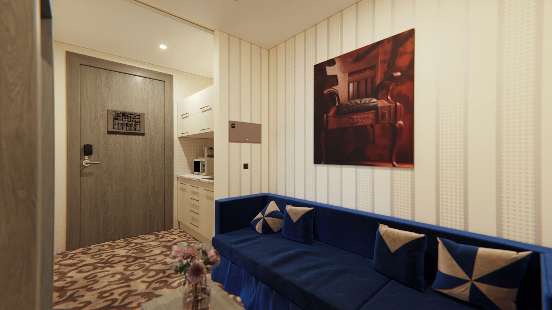 Quarto de hotel com porta de madeira, cozinha compacta, sofá azul com almofadas estampadas e uma obra de arte emoldurada na parede.