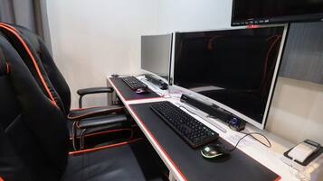 A gaming setup with two monitors, a keyboard, a mouse, and a chair.