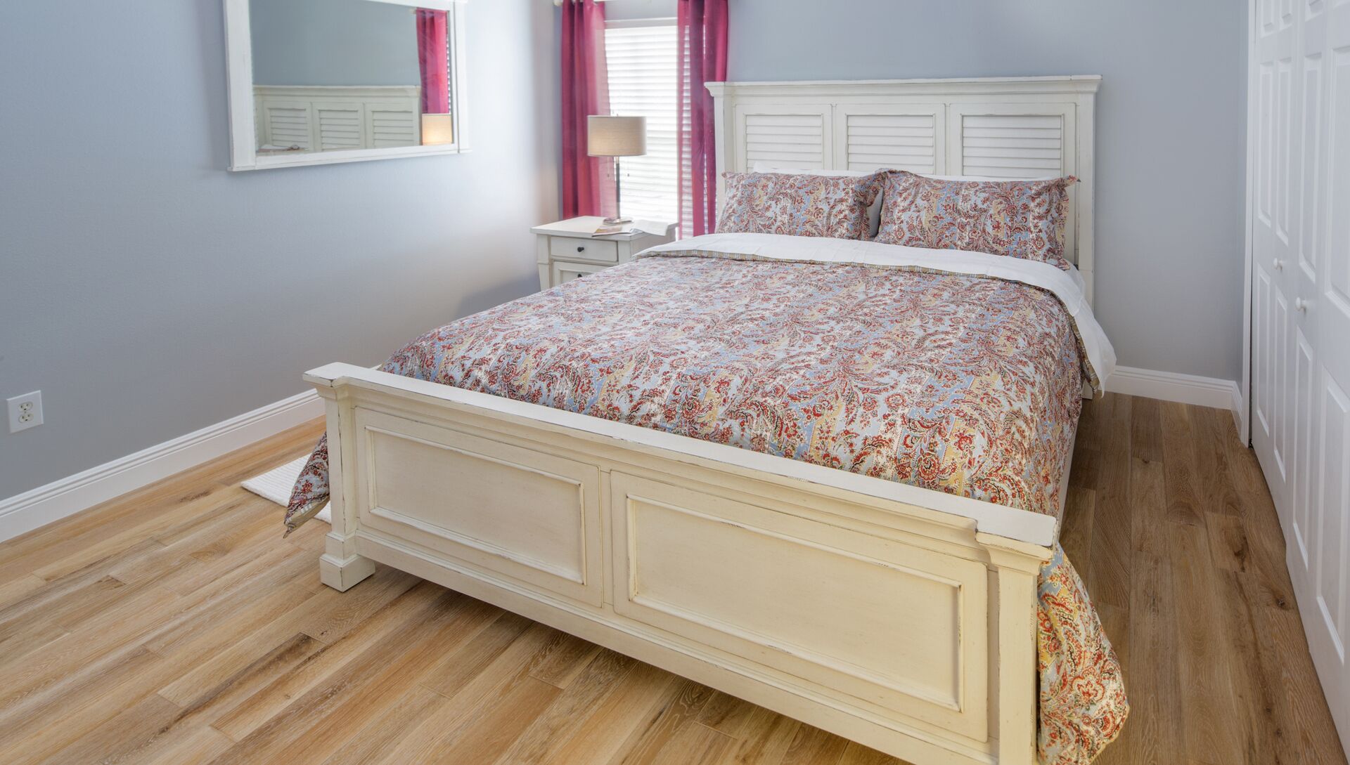 Une chambre à coucher avec un lit, une table de chevet et une commode.