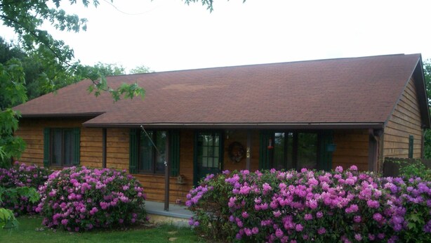A wooden house with a brown roof, green shutters, and a front porch. - Lovely cottage in West Asheville. Hot Tub. Pool open for SUMMER! (Asheville)