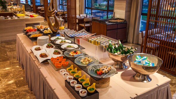 Een buffetopstelling met diverse gerechten en drankjes.
