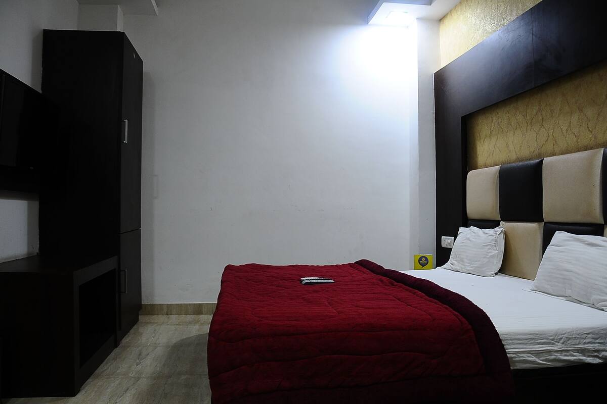 Una habitación de hotel con una cama, un televisor y un armario.