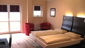 A bedroom with a bed, a desk, and a chair. - Hotel Kiose - Landhaus JOJO (Wenningstedt-Braderup)