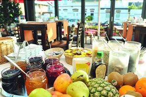 A table with various fruits, jars of preserves, and bottles of beverages, suggesting a cafe or restaurant setting. - Hotel Kiose - Landhaus JOJO (Wenningstedt-Braderup)