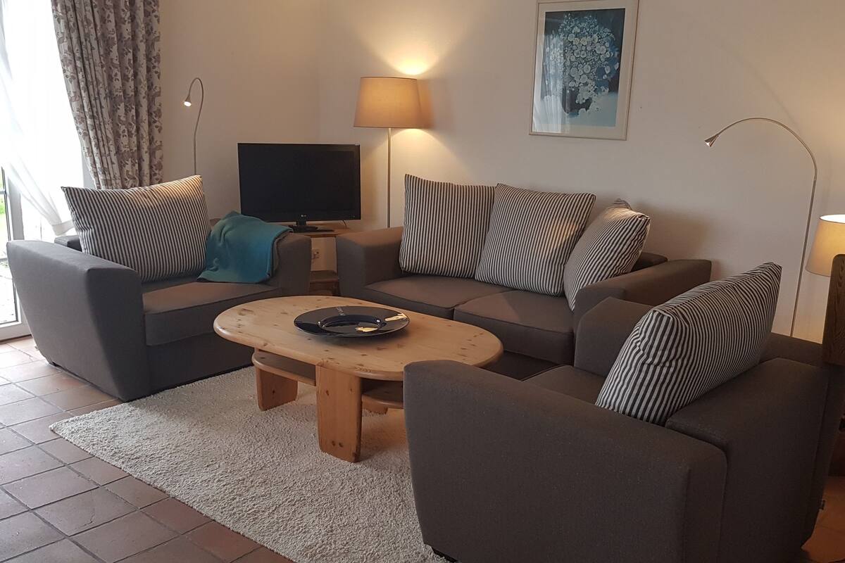 A living room with two sofas, a coffee table, a TV, and a lamp.