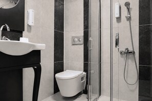 A modern bathroom with a sink, toilet, and glass-enclosed shower. - Elazığ Mavigöl Otel (Elazig)