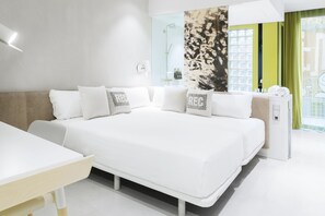 Una habitación de hotel moderna con una cama grande, una mesita de noche, un espejo y una ventana con vistas.