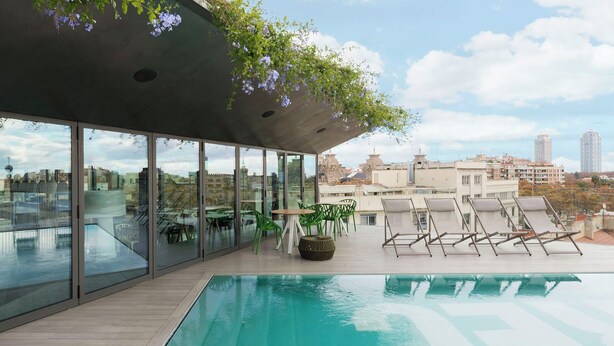 A rooftop pool with clear glass walls, a wooden deck, and lounge chairs. - Hotel Rec Barcelona - Adults only (Barcelona)