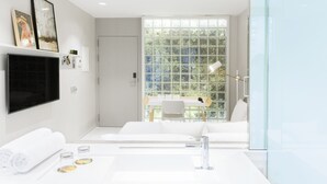A modern bathroom with a large window, a white sink, and a flat-screen TV mounted on the wall. - Hotel Rec Barcelona - Adults only (Barcelona)