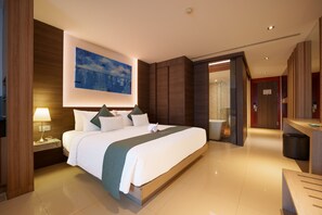 Una habitación de hotel con una cama grande, un escritorio, un baño y vistas al exterior.