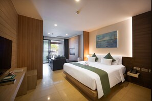 A modern hotel room with a large bed, a desk, a chair, and a view of the outdoors. - Kudo Hotel & Beach Club (Adults Only) (Patong)