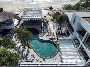 A rooftop pool area with lounge chairs and a central pool, overlooking a beach. - Kudo Hotel & Beach Club (Adults Only) (Patong)