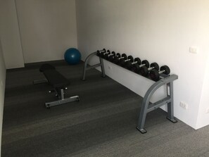 A gym with a bench, dumbbells, and a blue exercise ball. - Kudo Hotel & Beach Club (Adults Only) (Patong)
