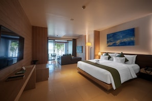 A modern hotel room with a large bed, a desk, and a view of the outdoors. - Kudo Hotel & Beach Club (Adults Only) (Patong)