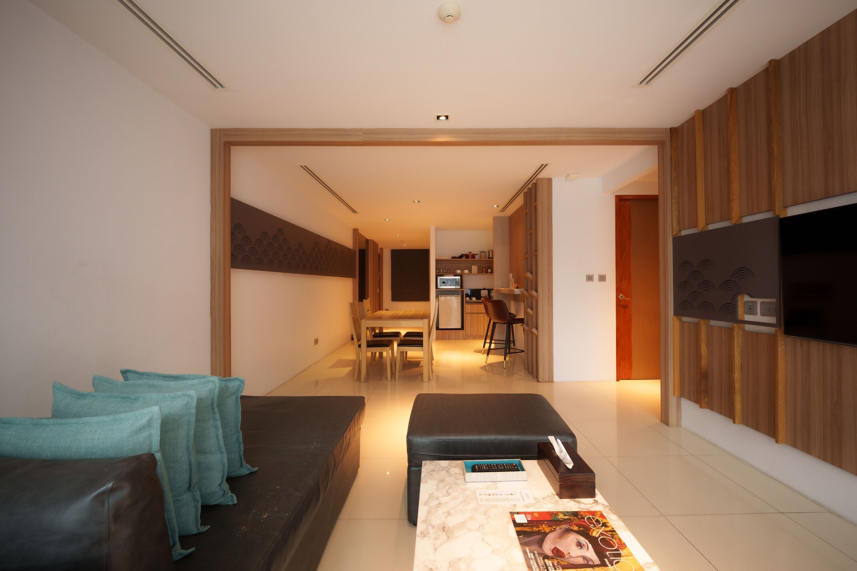 A modern living room with a sofa, a coffee table, and a TV.