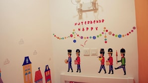 Une chambre d’enfant décorée sur le thème du « Casse-Noisette », avec une décoration murale comprenant une figurine de Casse-Noisette et un sapin de Noël.