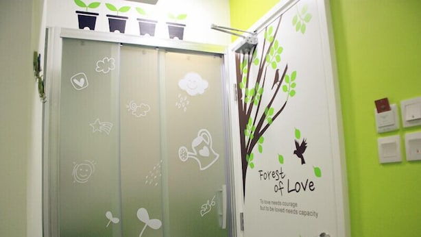 Une porte ornée d’un motif représentant un arbre et portant l’inscription « Forêts de l’amour ».