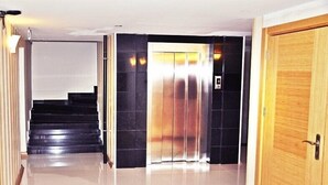 A hallway with a staircase leading to an elevator. - Bayazit Hotel (Iskenderun)