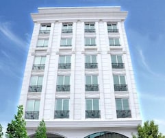 Um edifício alto e branco com várias janelas e varandas.