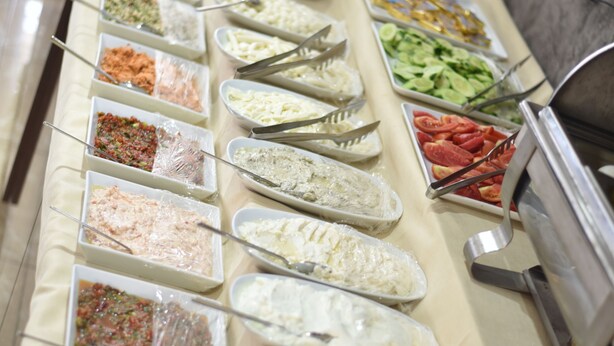 A buffet with various food items arranged in trays. - Bayazit Hotel (Iskenderun)