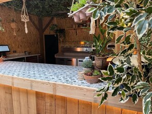 A kitchen with a wooden countertop, hanging plants, and a built-in stove. - The Admiral Cunningham Hotel (Bracknell)
