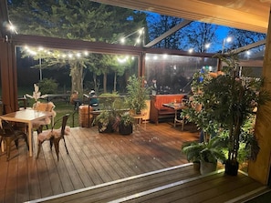An outdoor deck with wooden flooring, potted plants, and string lights. - The Admiral Cunningham Hotel (Bracknell)