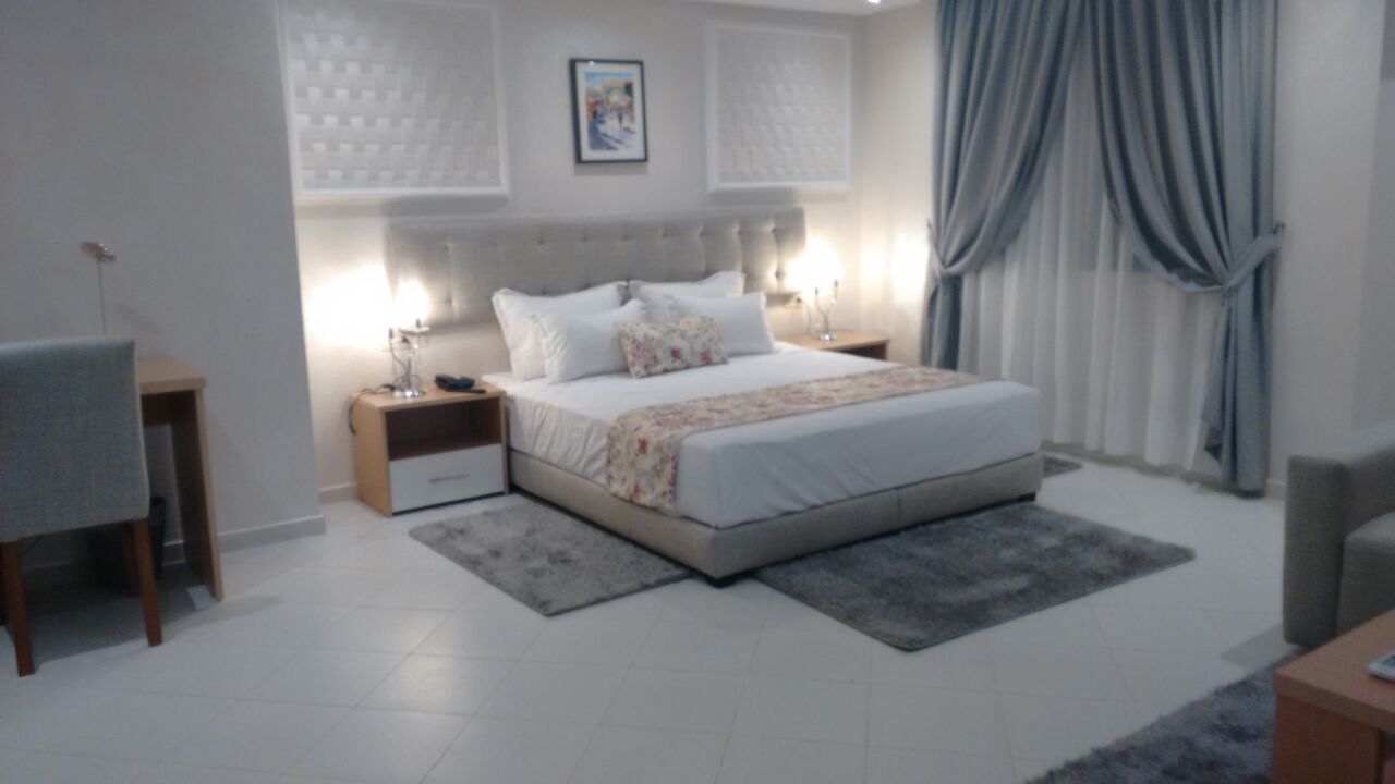 Une chambre moderne avec un grand lit, des tables de chevet, un bureau et une chaise.