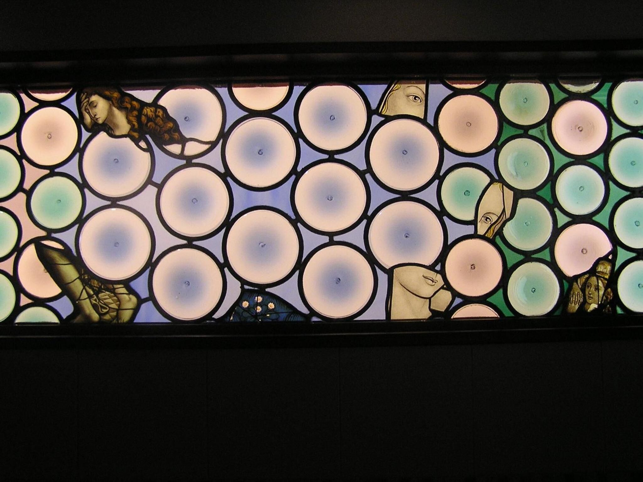 A stained glass window with circular patterns and figures.
