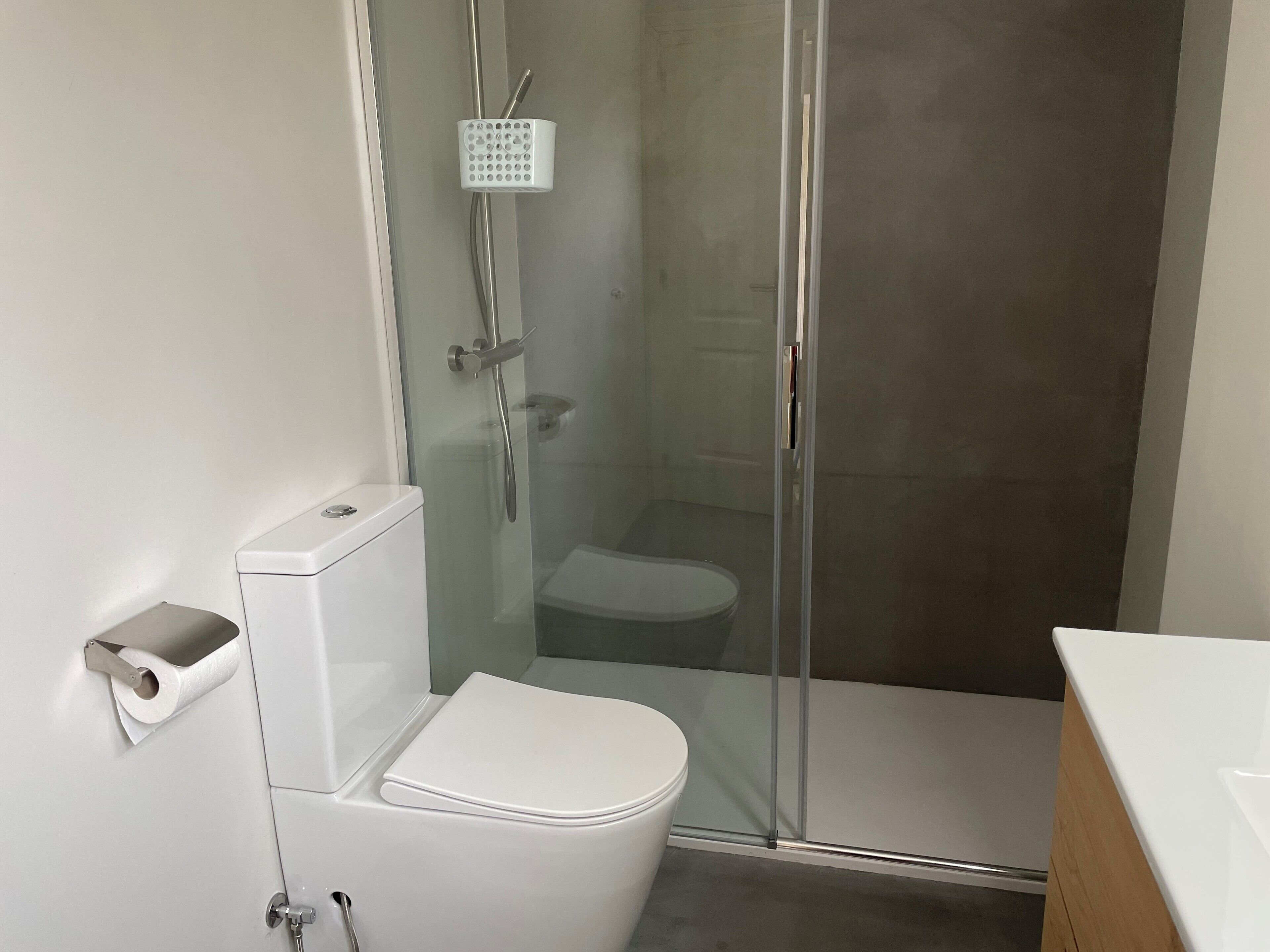 Ein modernes Badezimmer mit Toilette, Duschkabine und Waschbecken.