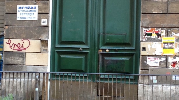 A green double door with a sign above it reading "AFFITTACAMERE" and "VITTORIA".