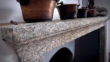 A stone shelf with three copper pots of varying sizes.