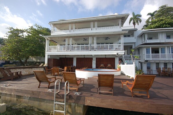 A two-story building with a pool, outdoor seating, and a staircase leading to the upper level. - San Bar 6BR by Jamaican Treasures (Port Antonio)
