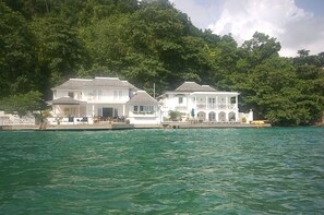 A waterfront property with a white building featuring multiple balconies and a dock.
