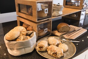 Una exhibición de panes y pasteles en una panadería.