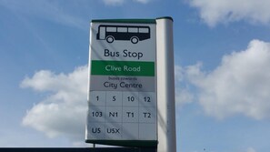 Señal de parada de autobús con indicaciones hacia Clive Road y el centro de la ciudad.