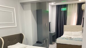 A hotel room with two single beds, a desk, a chair, a wardrobe, and a mirror. - Abam Hotel (Istanbul)