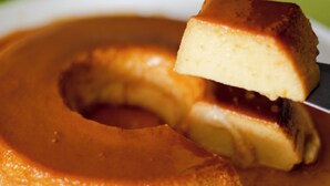 Un flan de caramelo en un plato, con una porción siendo levantada.
