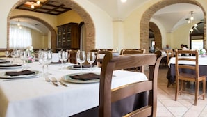 A restaurant with tables set for dining, featuring brick arches and hanging lights. - La Vecchia Torre (San Nicola Manfredi)