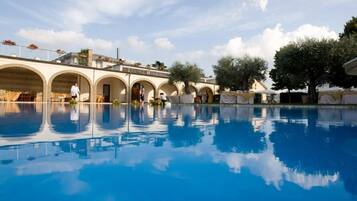 Una piscina al aire libre de temporada, sombrillas