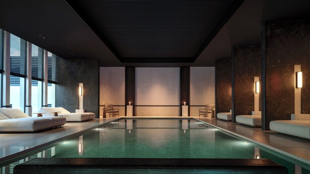 A modern indoor swimming pool with a minimalist design, featuring a central pool area, seating areas, and ambient lighting. - La Réserve (Knokke-Heist)