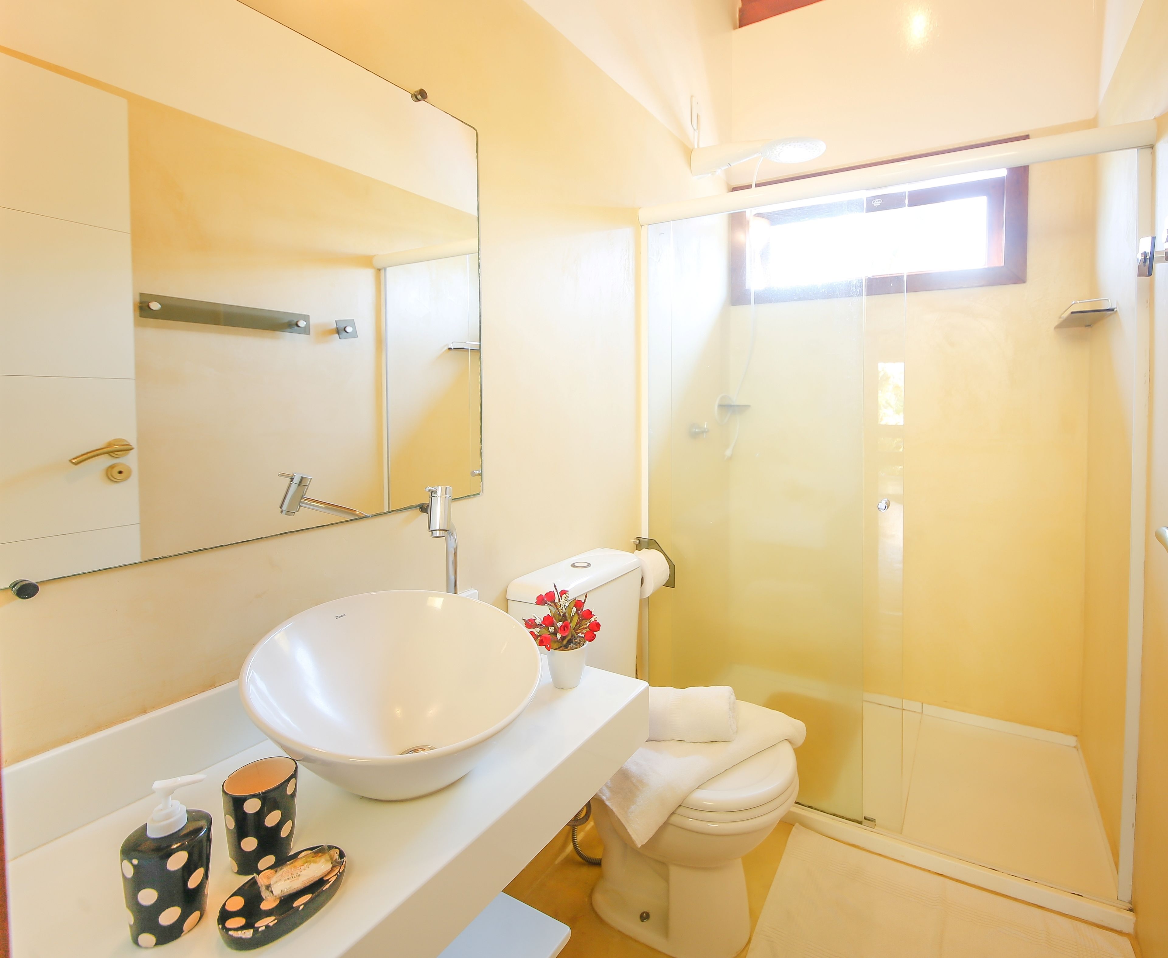A bathroom with a white sink, a toilet, and a glass-enclosed shower.