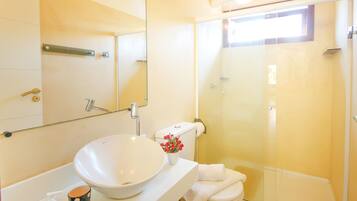 A bathroom with a white sink, a toilet, and a glass-enclosed shower.