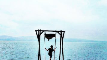 Una persona parada en un columpio dentro del agua.
