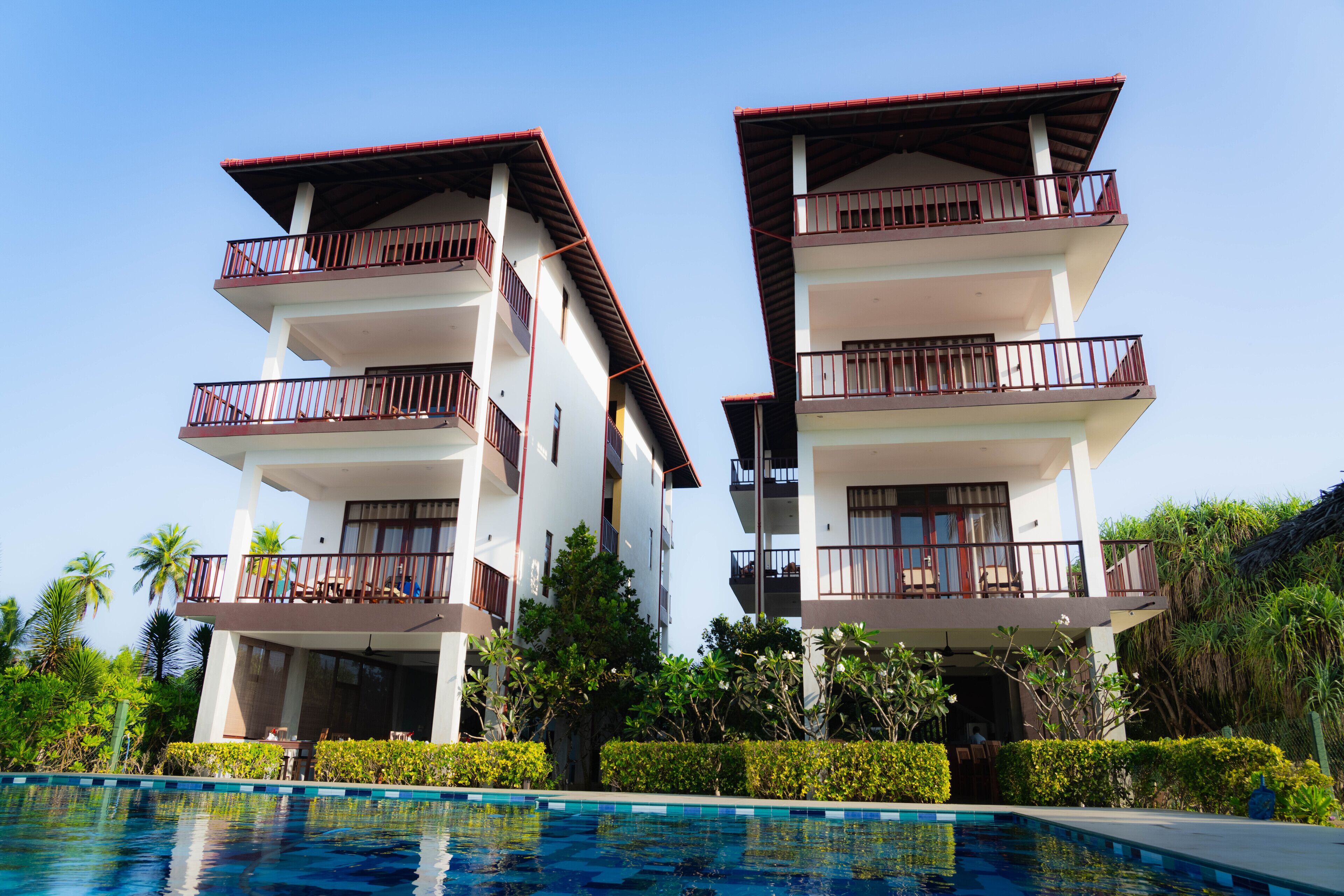 A two-story hotel with balconies and a swimming pool.