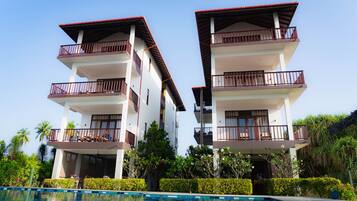 A two-story hotel with balconies and a swimming pool.