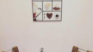 Una pequeña mesa de comedor con dos sillas de cuero marrón, una planta en maceta y una taza de café.