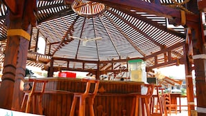 A wooden pergola structure with a pool table and chairs at the El Hayah Resort - Pergola Pool Cafe. - Alhayat Ain El Sokhna (Ataqah)
