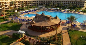 A resort with a central pool, multiple levels of balconies, and outdoor seating areas.