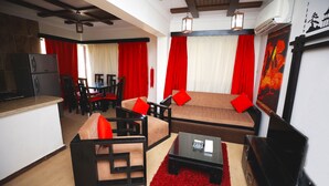 A modern living room with a sofa, chairs, a coffee table, and a TV. - Blue Bay Asia Resort El Sokhna (Ataqah)