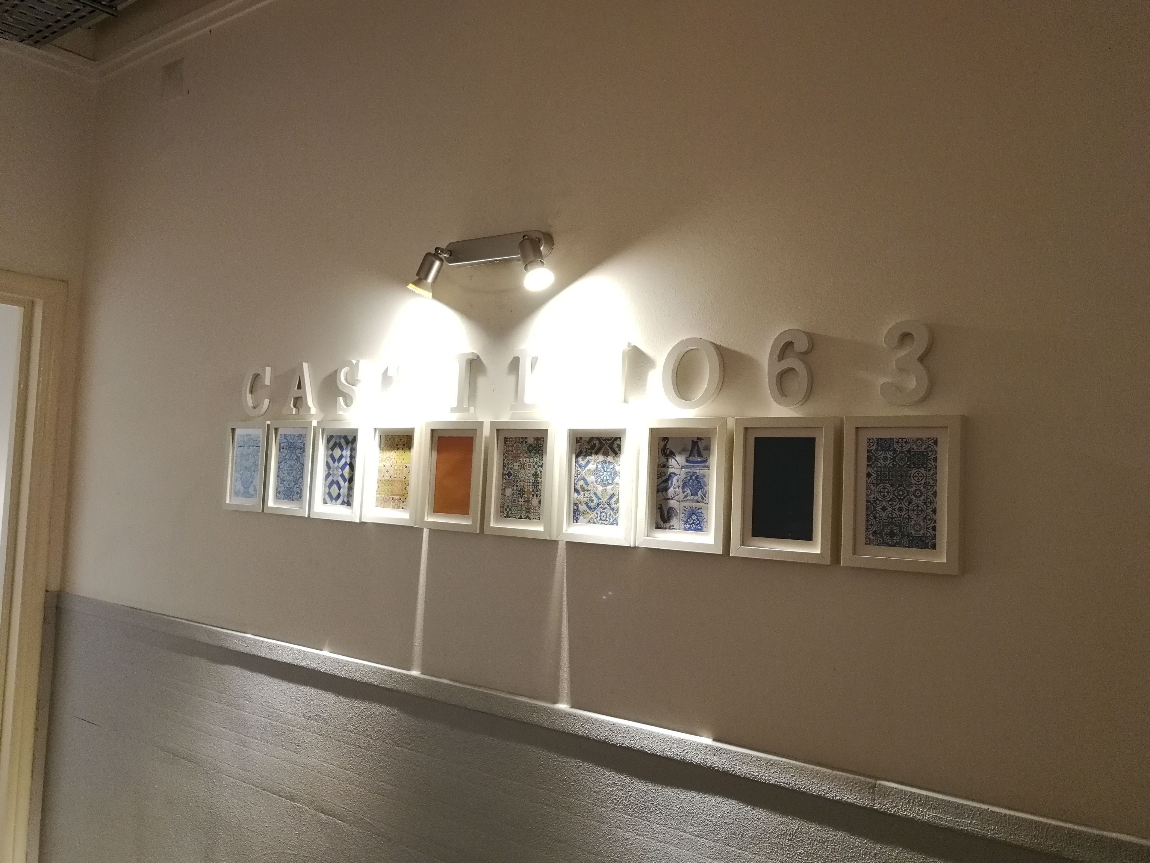 A wall with the text "CAST IT 1063" and framed tiles.